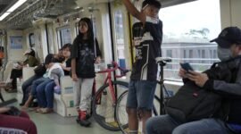 Dua orang anak muda-mudi menggunakan sepeda non lipat naik LRT Jabodebek. (Foto/Humas KAI).
