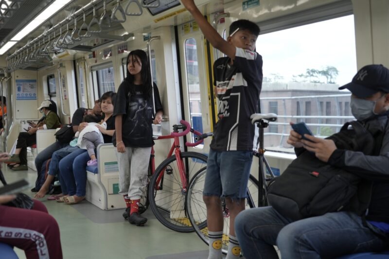 Dua orang anak muda-mudi menggunakan sepeda non lipat naik LRT Jabodebek. (Foto/Humas KAI).