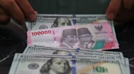 Karyawan merapihkan uang dolar AS dan rupiah di salah satu tempat penukaran uang di Jakarta.